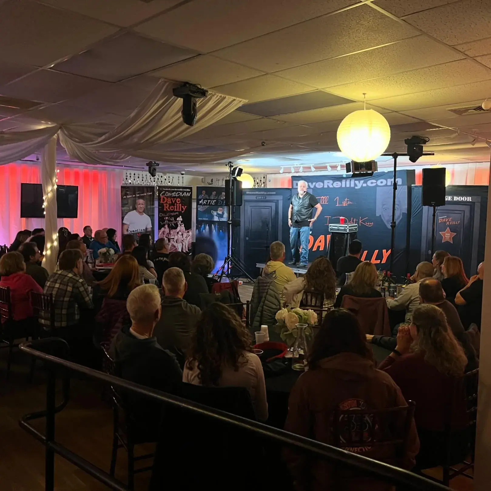 A live entertainment night at Titanium Theatre — a full room seated at tables facing the lit stage